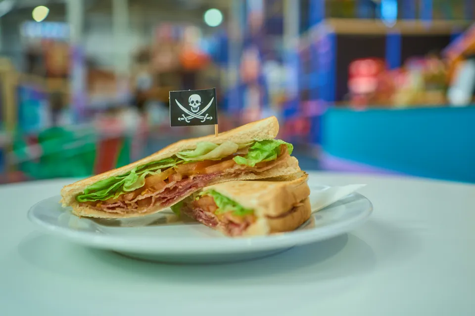 A toasted bacon, lettuce and tomato sandwich with a small pirate flag
