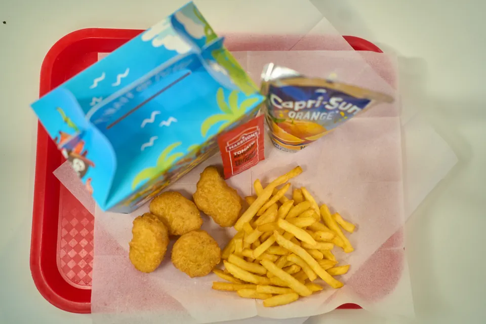 Chicken nuggets and fries beside a pirate-themed meal box and Capri-Sun