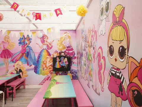 Pink themed private party room with tables prepared and no guests present.