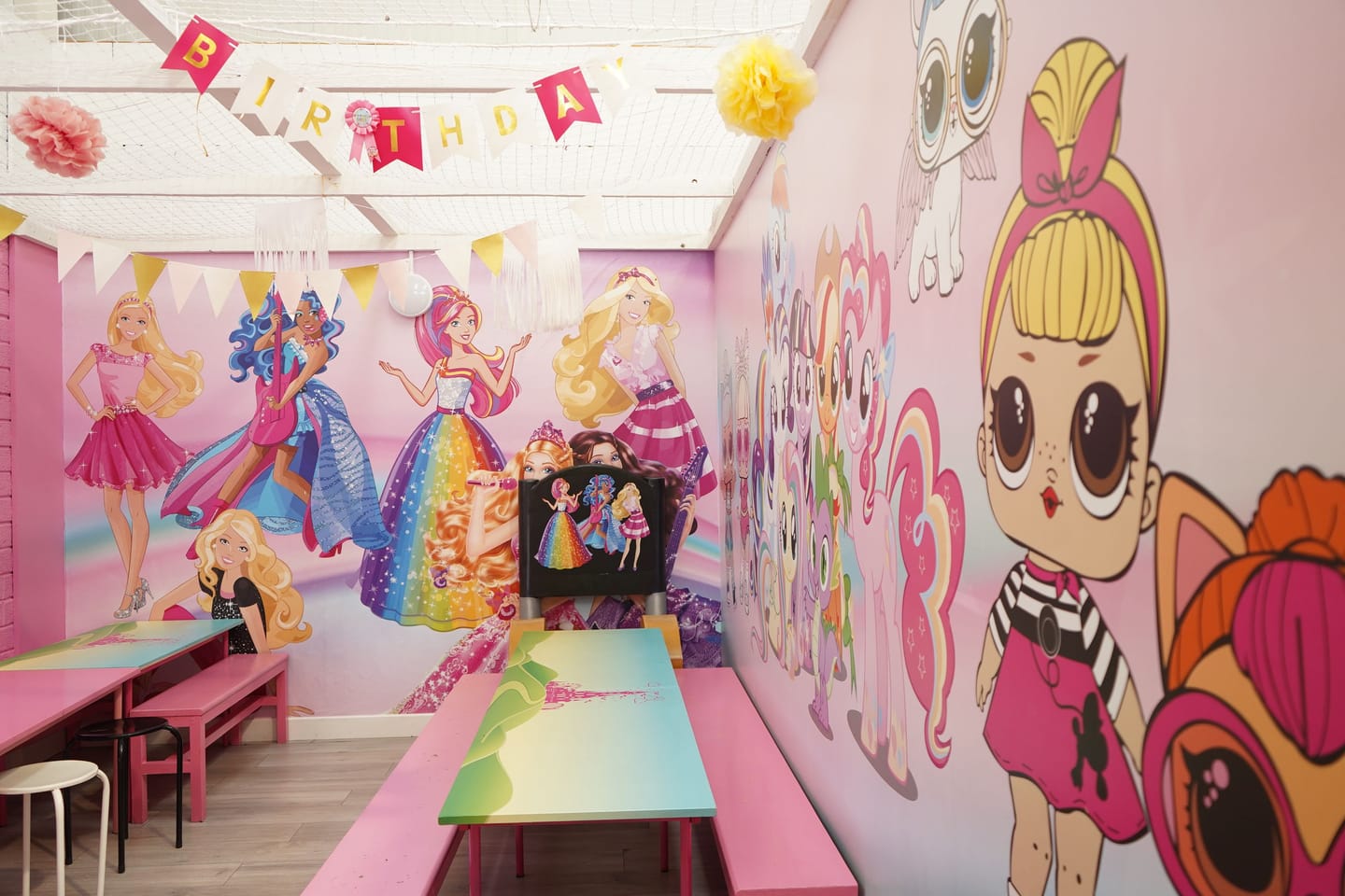 Pink themed private party room with tables prepared and no guests present.