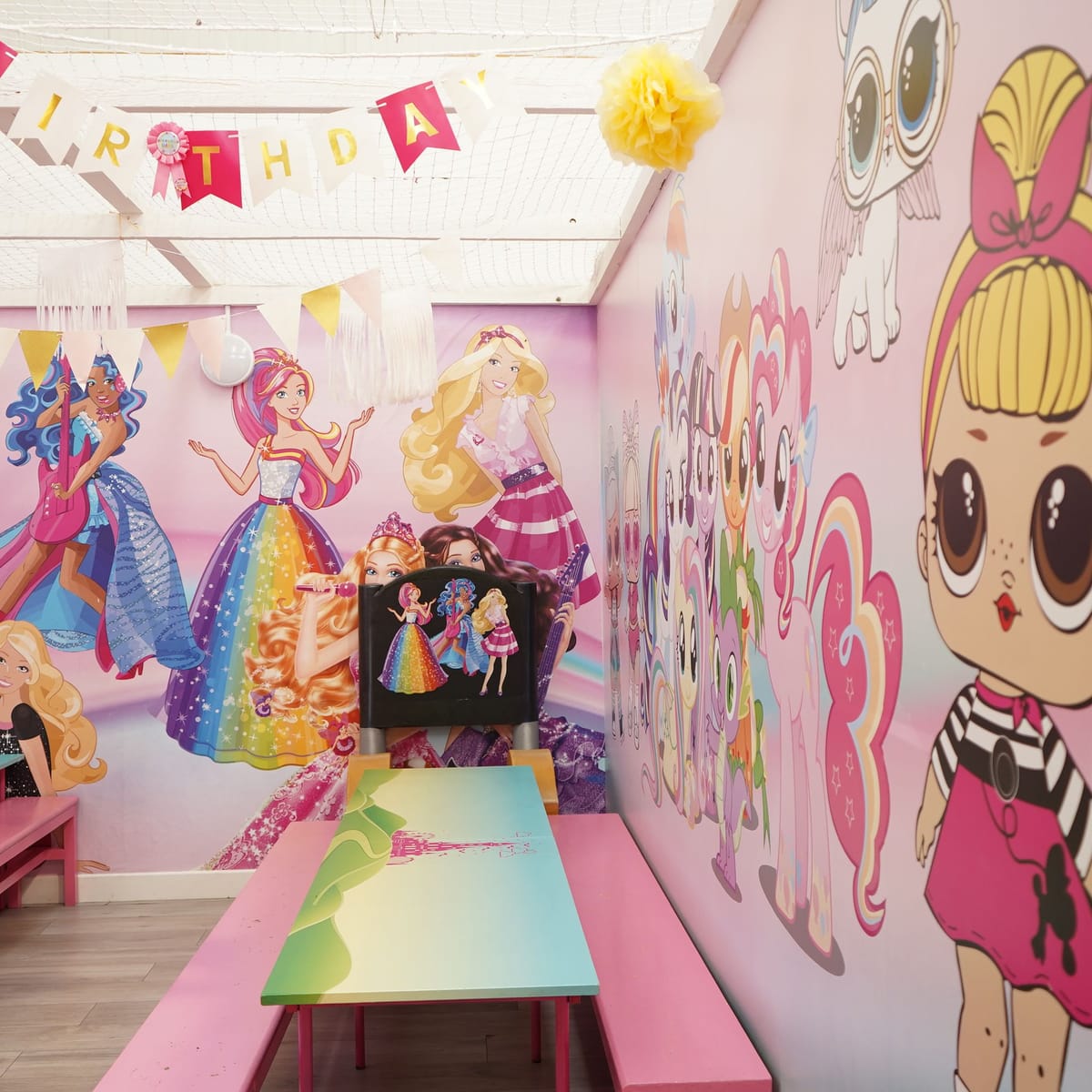 Pink themed private party room with tables prepared and no guests present.