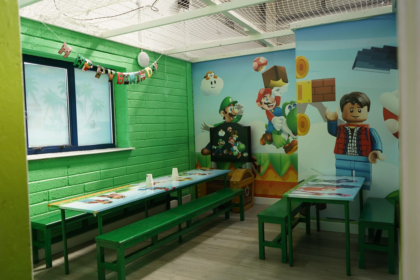 Gaming themed private party room with tables prepared and no guests present.