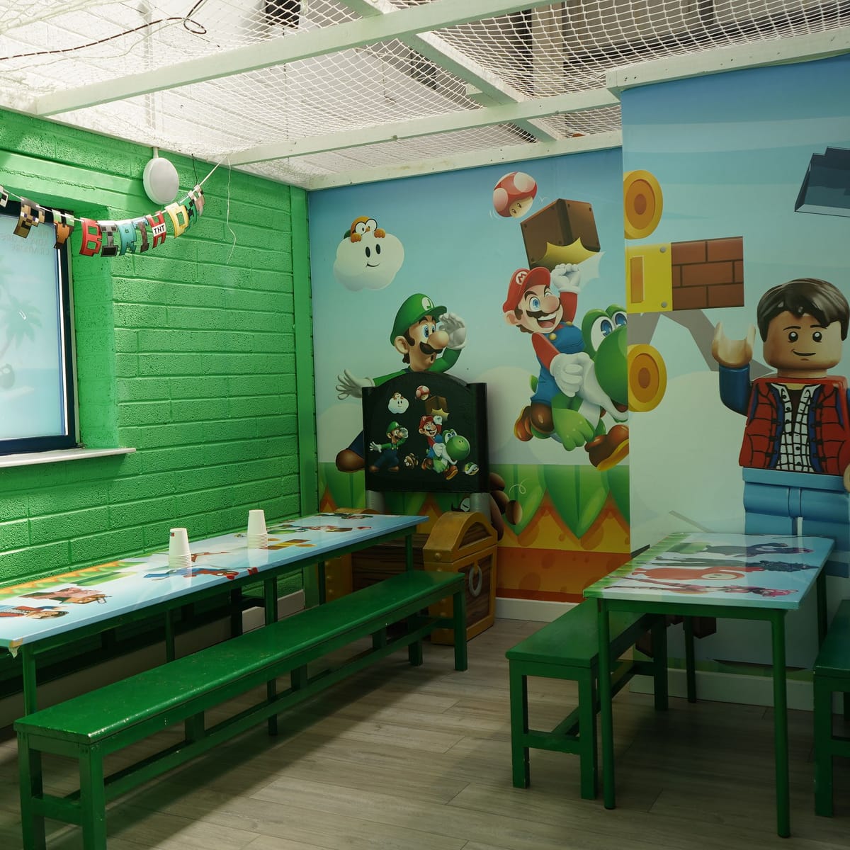 Gaming themed private party room with tables prepared and no guests present.