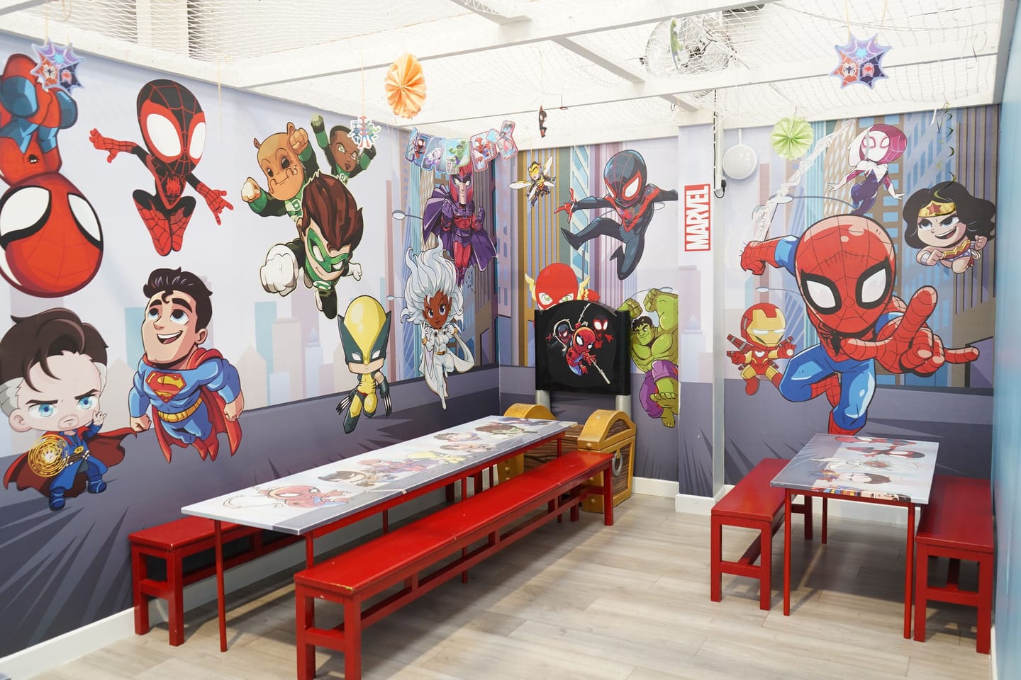 Superhero themed private party room with tables prepared and no guests present.