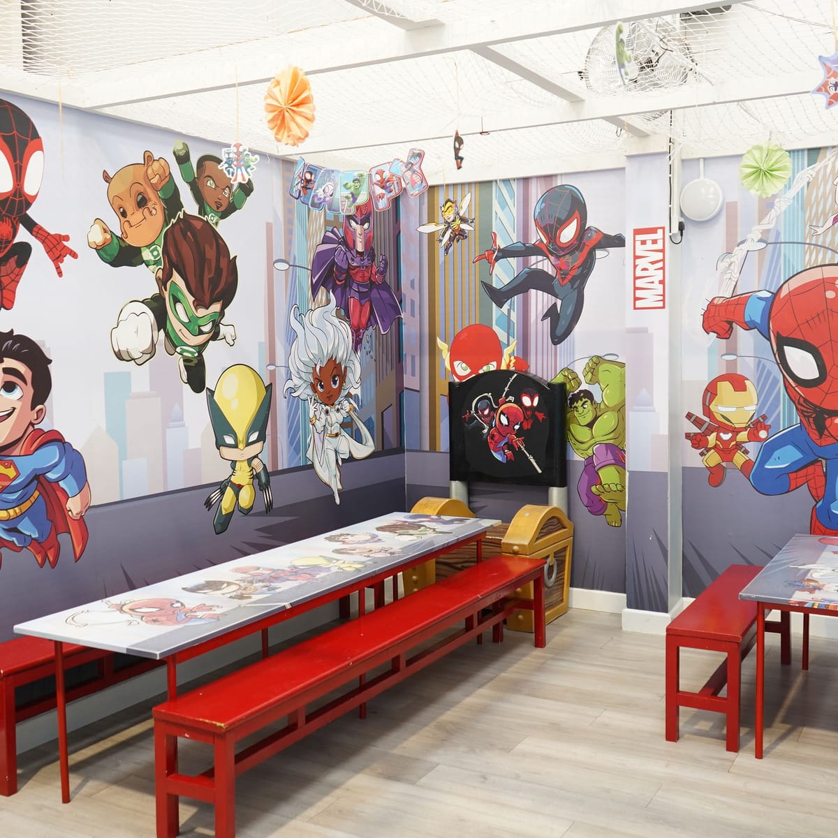 Superhero themed private party room with tables prepared and no guests present.