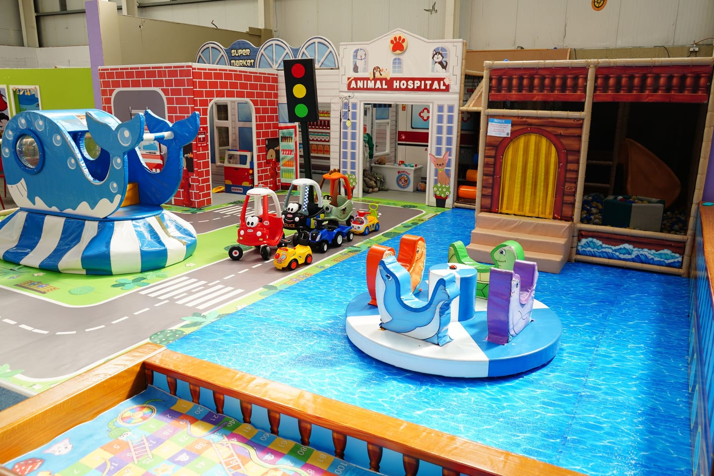 Wide view of the separate Toddler Area with low play features and role-play façades.