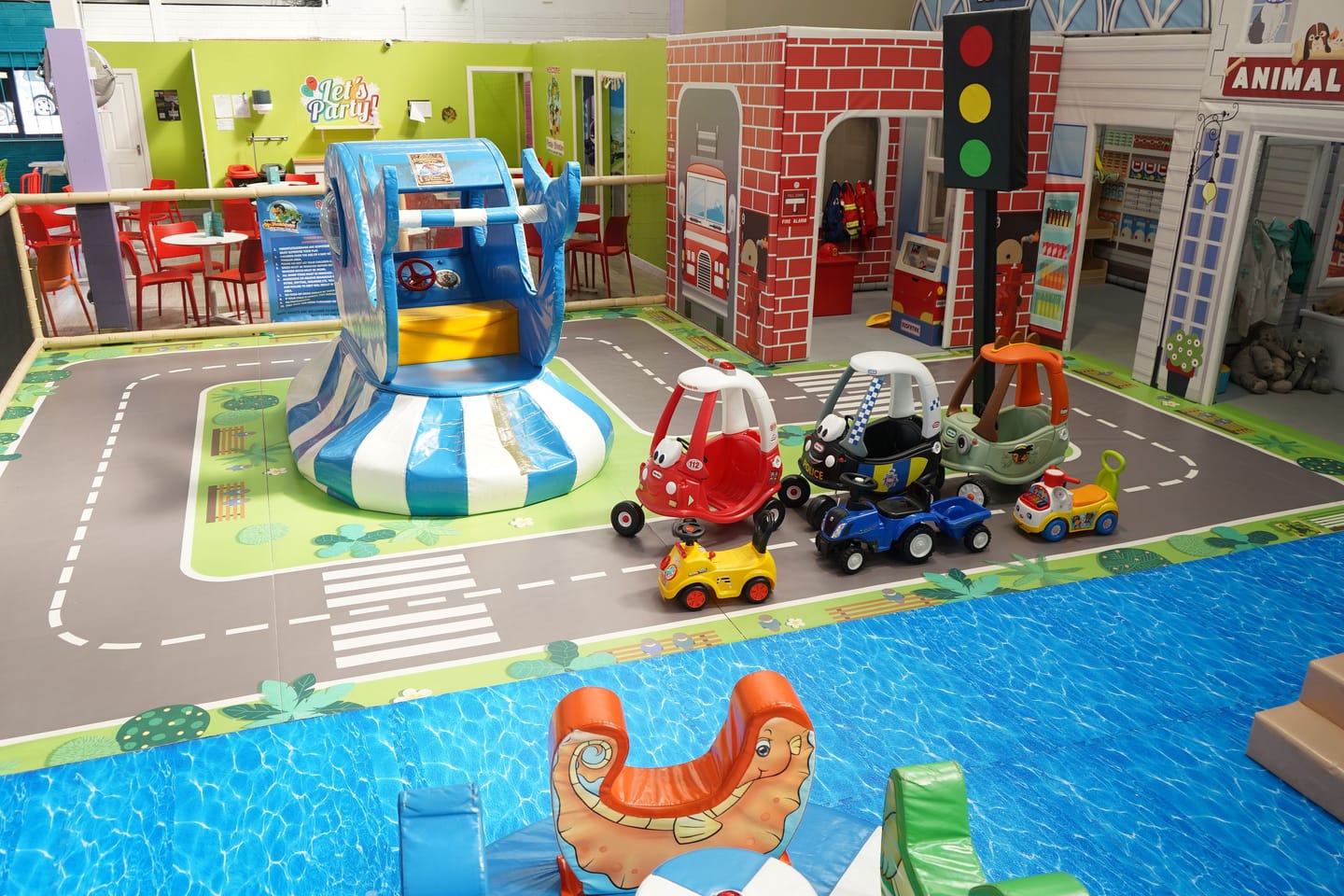 Wide view across the Toddler Area role-play street and ride-on cars.